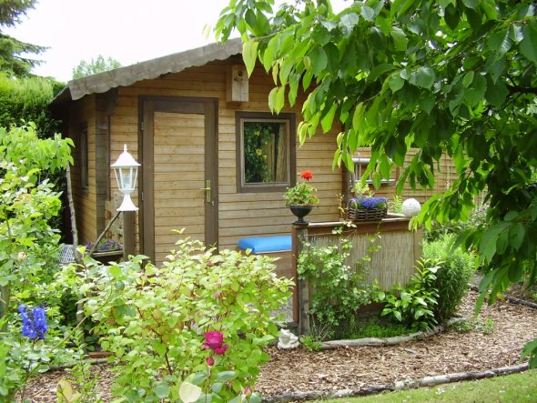 Diese kleine Hütte ist voll mit Deko für den Garten, hauptsächlich Körb und Pflanzgefäße.